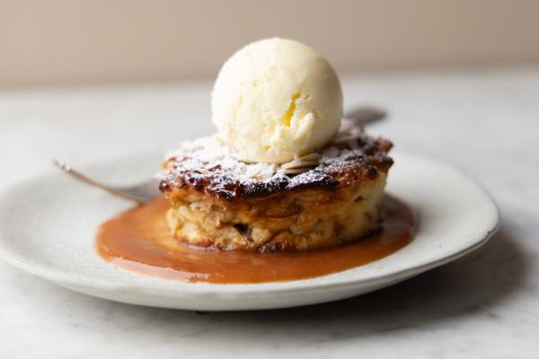 bread pudding on a plate with a scoop of vanilla ice cream