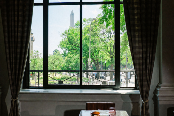 view of a dining table set for two in front of large windows with a view overlooking the Washington Monument
