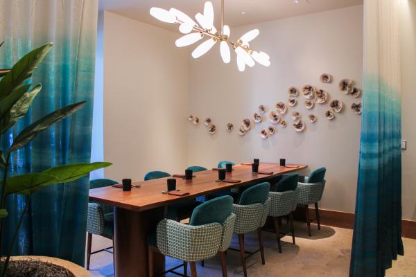 bright light private dining room with a wood slab table and blue chairs and detailing