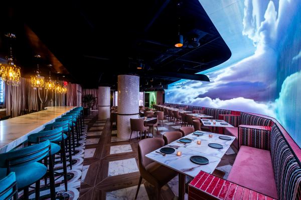 Closer shot of light room with cloud imagery on screen