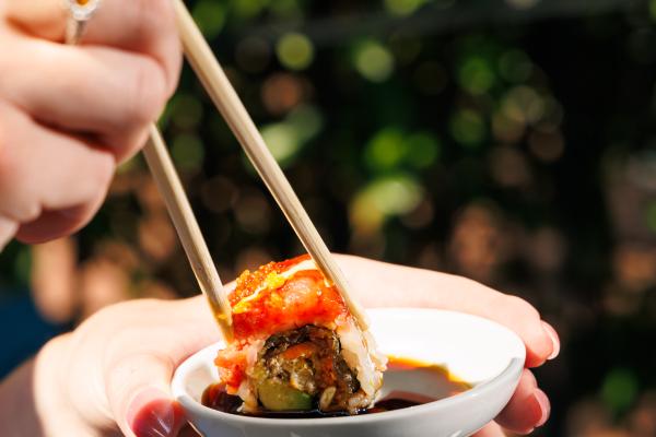 sushi dipping in soy sauce